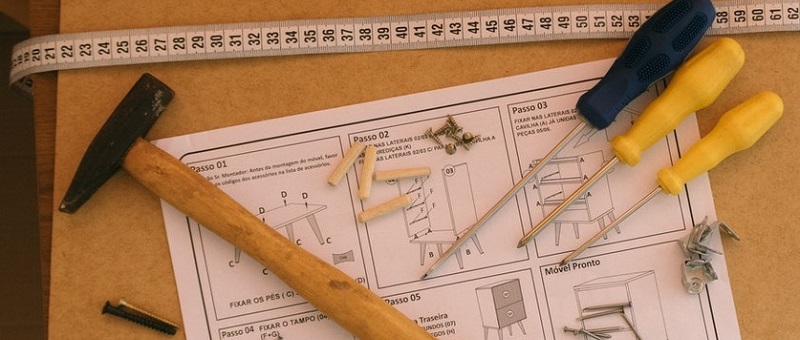 Photo of a hammer and tools lying on a workbench