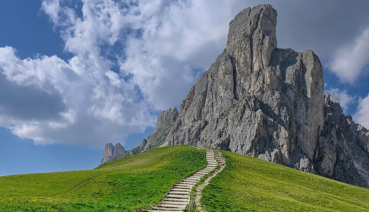 A mountain trail winding its way towards a towering peak.