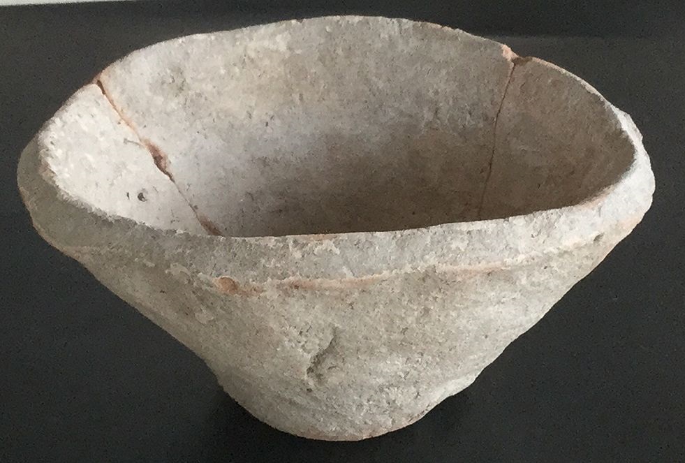 A simple clay bowl with a narrow, flat base, straight sides, and a beveled rim